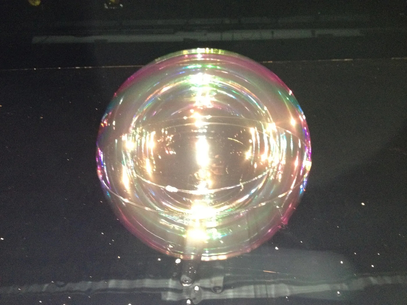 Une bulle irisée éclairée dans le noir