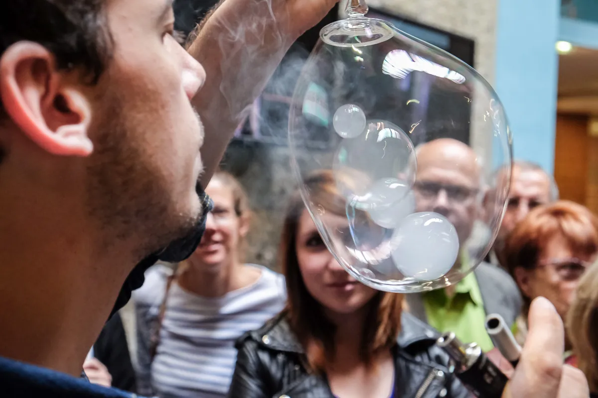 Des spectateurs regardent une bulle de fumée de très près