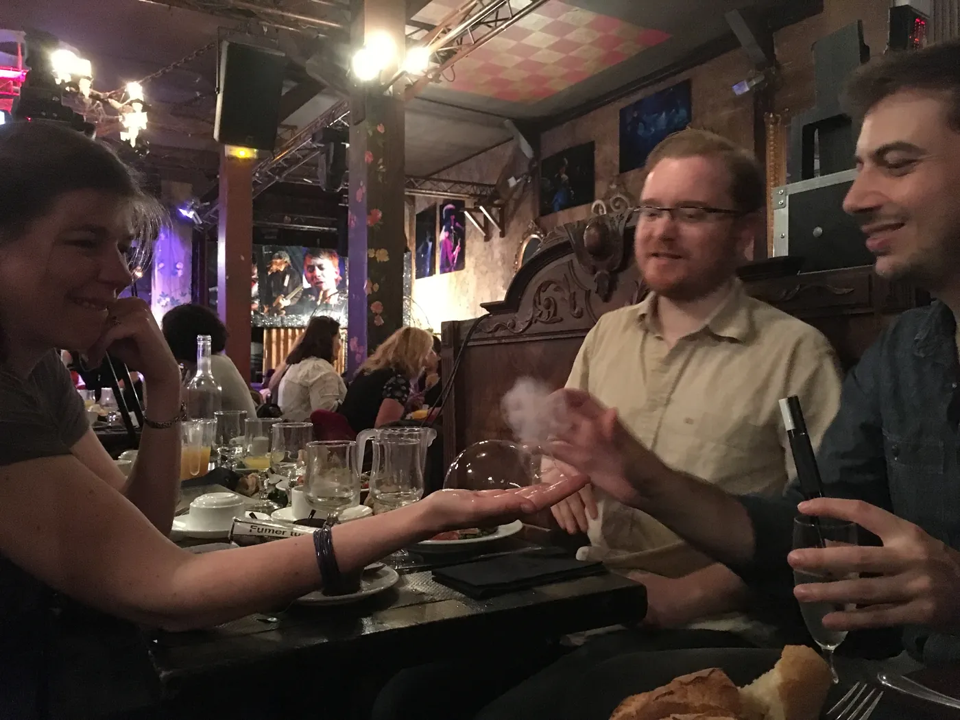 Close-up à table : une bulle passe dans la main d'une invitée