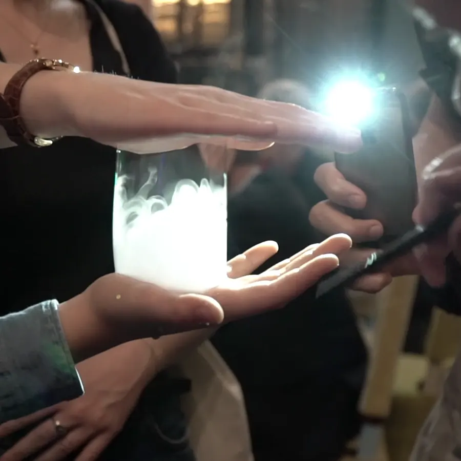 Une bulle remplie de fumée s'illumine entre les mains d'invités